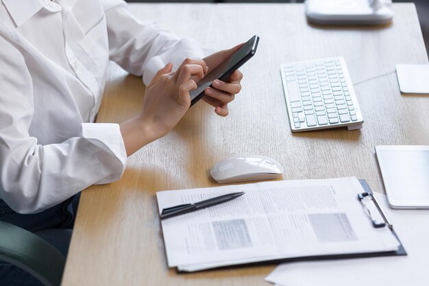 Closeup photo of female hands using the phone business woman at work