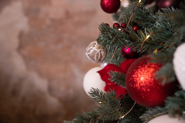 ぶら下がっているリビングルームの白い赤いクリスマスの装飾のモミの木のお祝いのボールのクローズアップ写真...