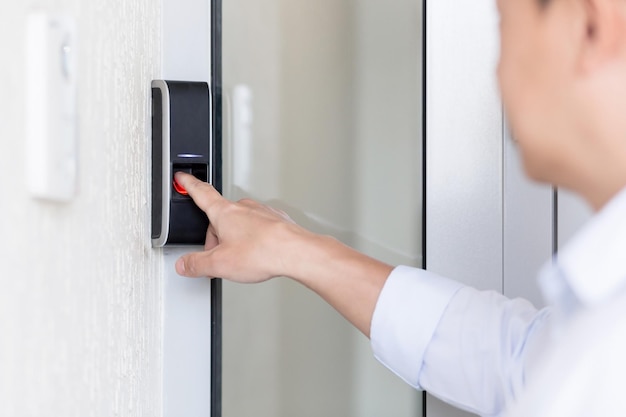 Closeup photo the hand of a young man in a white shirt calls the intercom of the house presses the