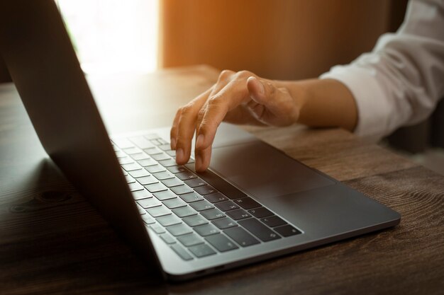 Closeup photo of male hands with laptop fingers touch keyboard concept