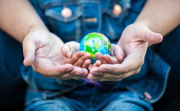 Closeup photo of man holding girls hands with earth globe