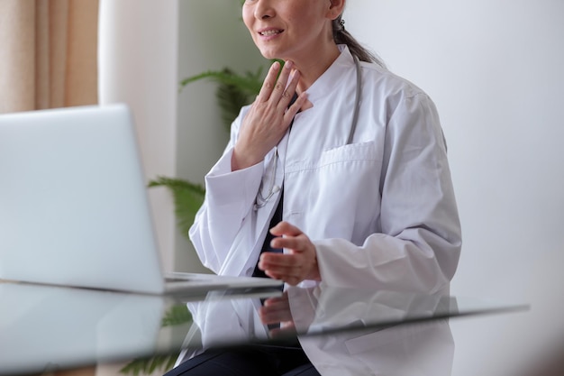 Closeup photo of medical worker putting her hand to throat