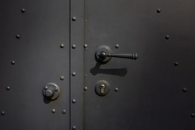 Closeup photo of a metal door with handle and lock