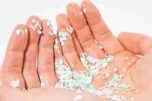 Photo a closeup photo of microplastics lay on human hand concept of water pollution and global warming the idea of environmental damage white background