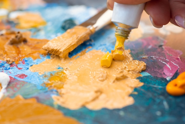 Closeup photo of palette in different inks and a brush in the background