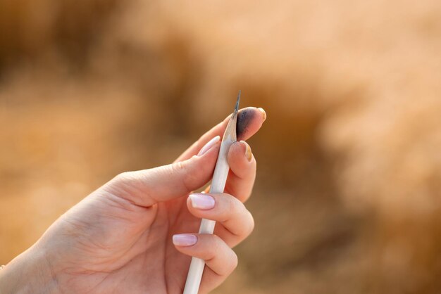 Closeup photo of a pencil in hand of an artist Sharpening pencil before drawing