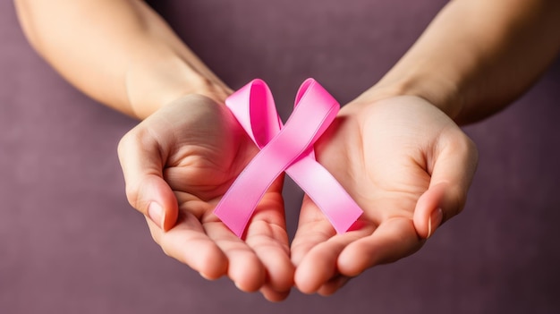 A closeup photo of a pink ribbon being held in the hands of a woman