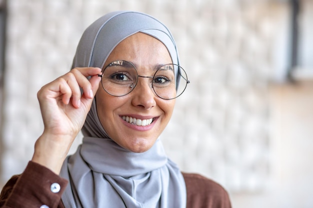 Фотопортрет крупным планом молодой красивой мусульманки в хиджабе, улыбающейся и смотрящей в камеру