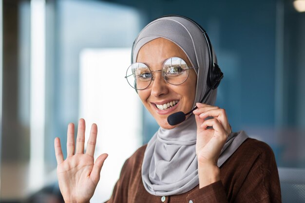 Closeup photo portrait of young hispanic woman in hijab and headset talking consulting advising