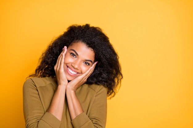 Closeup photo of pretty amazing dark skin lady holding arms on cheekbones enjoy warm spring sunny day wear casual pullover isolated yellow color background