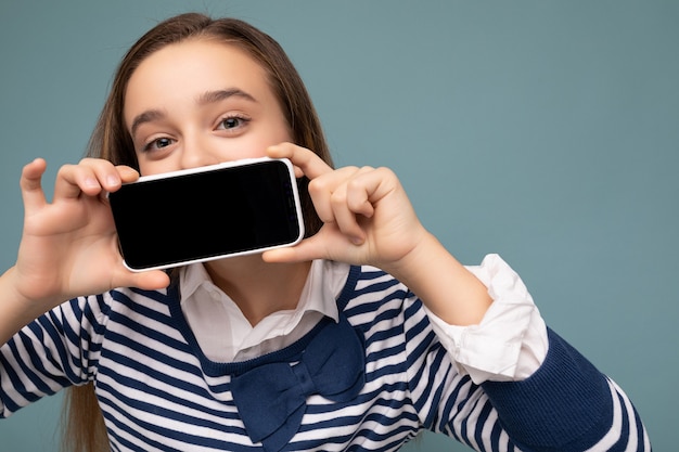 Closeup photo of Pretty positive brunette girl wearing striped long sleeve standing isolated on blue