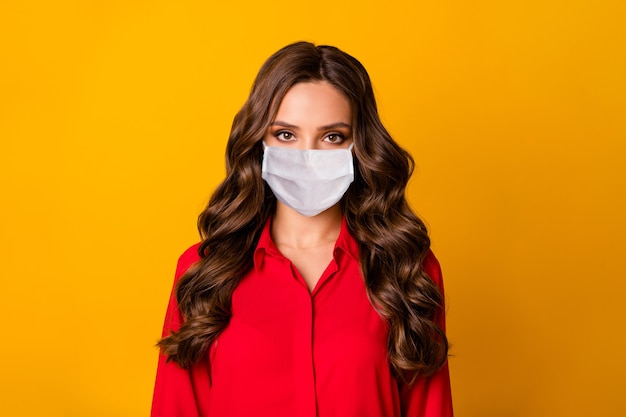 Closeup photo of pretty stunning curly business lady  serious bossy person wear medical mask office luxury red shirt isolated yellow vivid color background