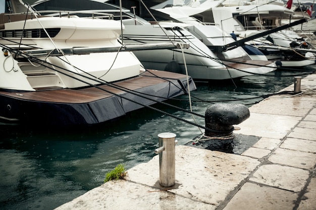 Closeup photo of row of moored yachts at rainy day