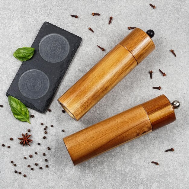 Closeup photo of salt and pepper mills lying on gray background