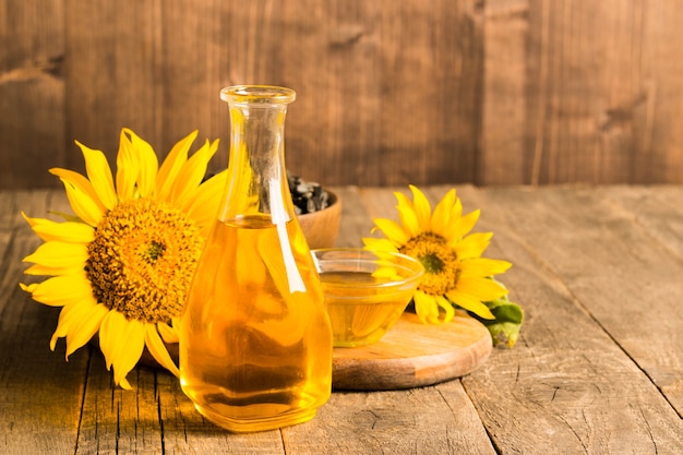 Closeup photo of sunflower oil with seeds on wooden background. bio and organic product concept