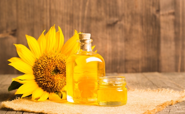 Closeup photo of sunflower oil with seeds on wooden background. bio and organic product concept