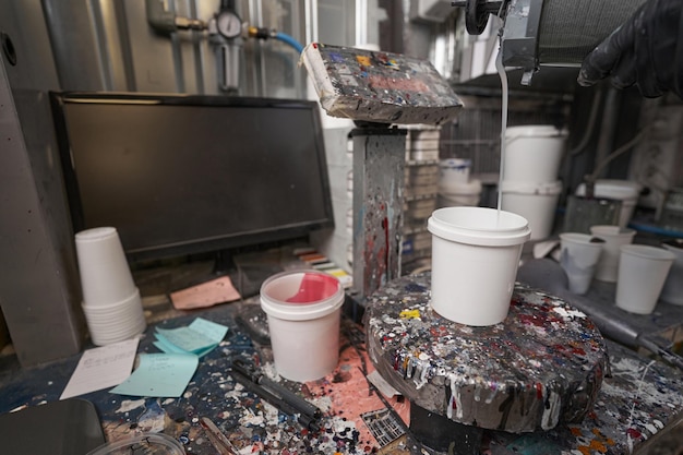 Foto primo piano del tavolo con bilancia computer e barattoli di vernice luogo per mescolare la vernice e la corrispondenza dei colori