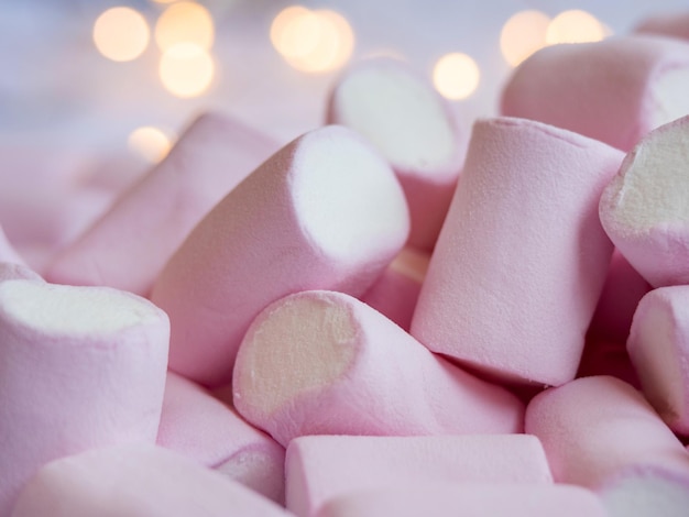 Photo a closeup photo of a tasty pinkwhite marshmallow with lights on a background