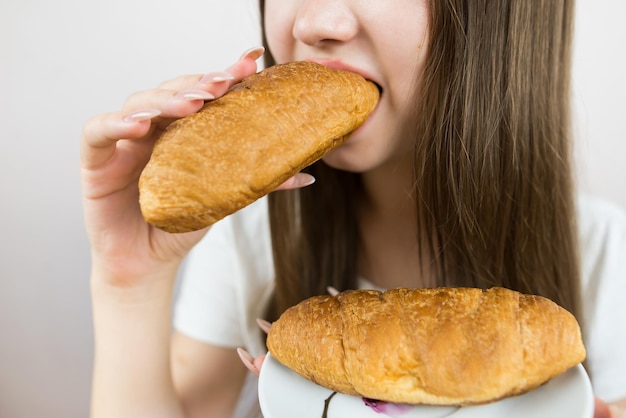 Closeup photo of a woman eating a croissant