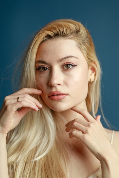 Closeup photo of young blue blonde on blue background