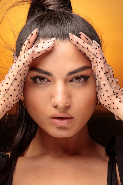 Closeup photo of young lady holding her hands to her face