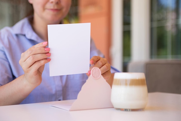 Fotografia del primo piano del regalo di certificato in bianco anonimo della donna