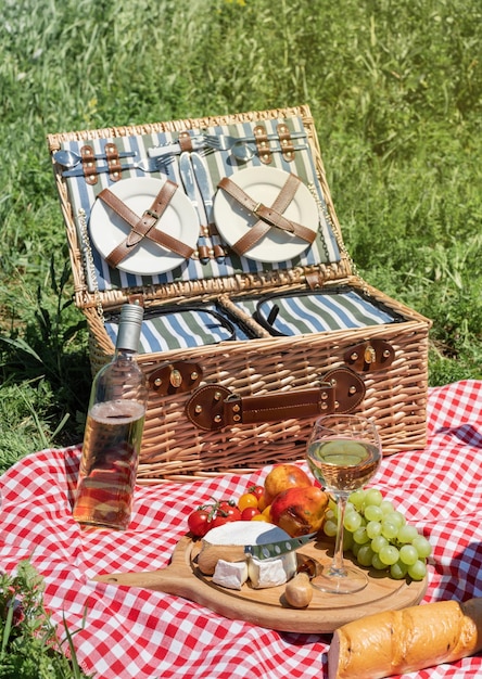 Primo piano del cestino da picnic con bevande e cibo sull'erba