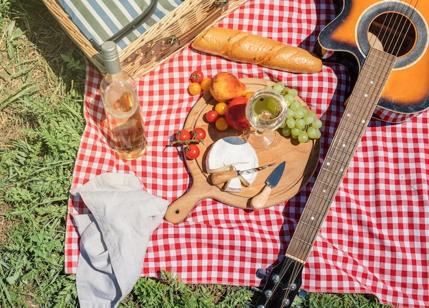 Closeup of picnic basket with drinks and food on the grass