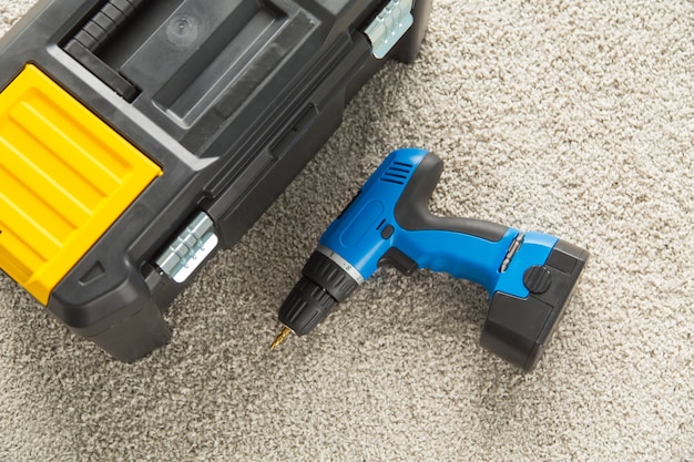 Closeup picture of black toolbox and blue drill