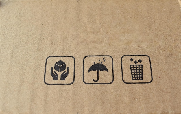 A closeup picture of a Icons on a packaging cardboard like fragile material do not wet and use the bin after use