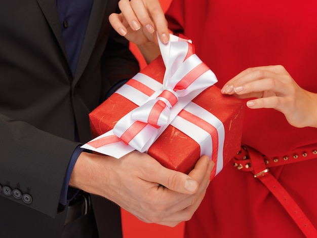 Primo piano delle mani di uomo e donna con confezione regalo