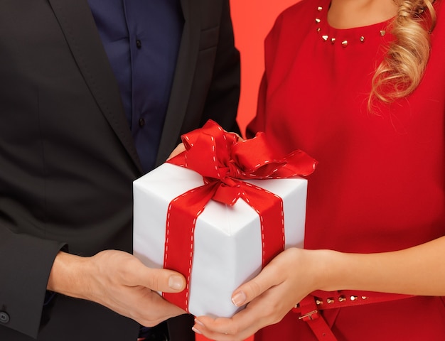 Foto primo piano delle mani di uomo e donna con confezione regalo