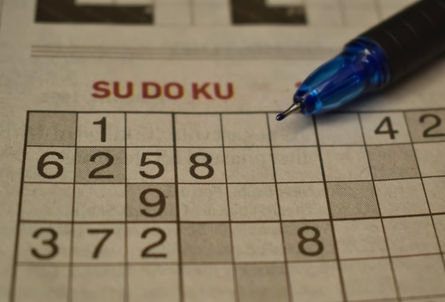 Foto un'immagine in primo piano del gioco sudoku con una penna sopra è un famoso puzzle numerico