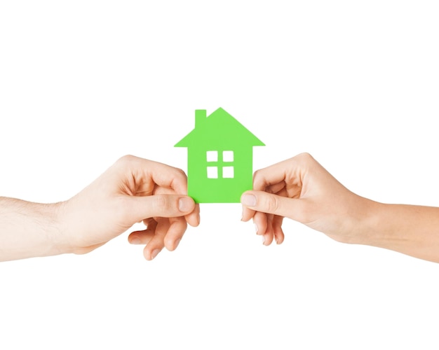 closeup picture of woman and man hands holding green house