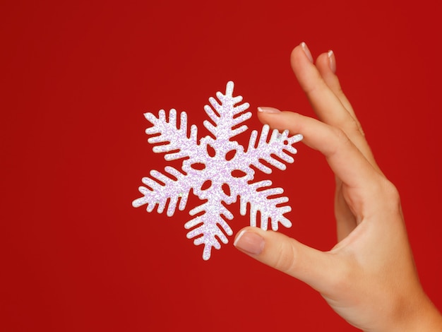 closeup picture of woman's hands holding a snowflake