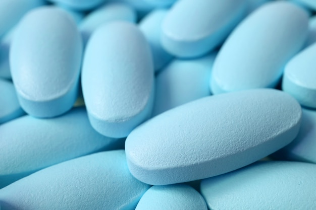 Closeup pile of light blue oval shaped pills