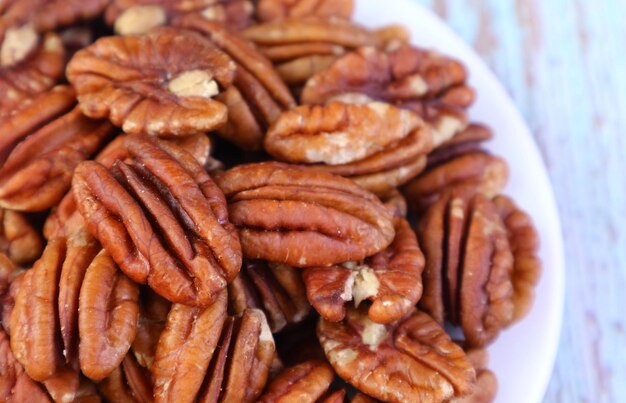 Closeup of Pile of Pecan Nuts on a White Plate