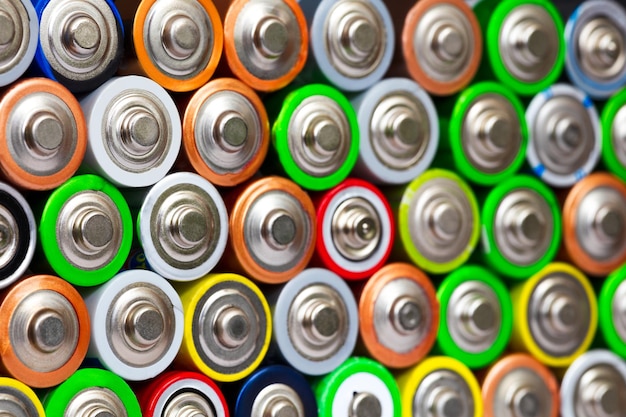 Closeup of pile of used alkaline batteries Close up colorful rows of selection of AA batteries energy abstract background of colorful batteries Alkaline battery aa size Several batteries in rows