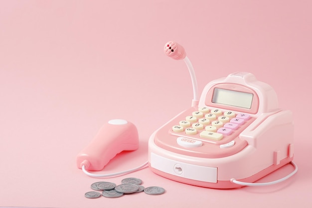 closeup pink toy cash register on pink background, play store