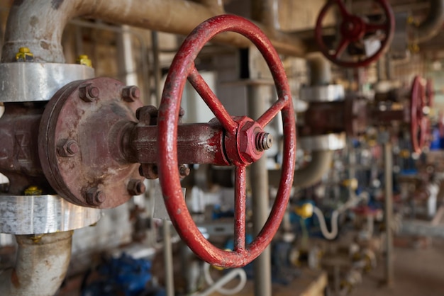 Closeup at pipeline valve which is using to control production\
process in the oil refinery plant sel