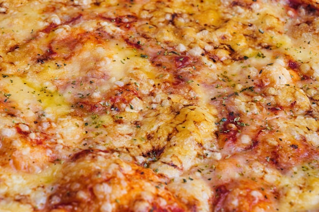 Closeup of pizza topped with cheese and oregano macro shot of delicious products