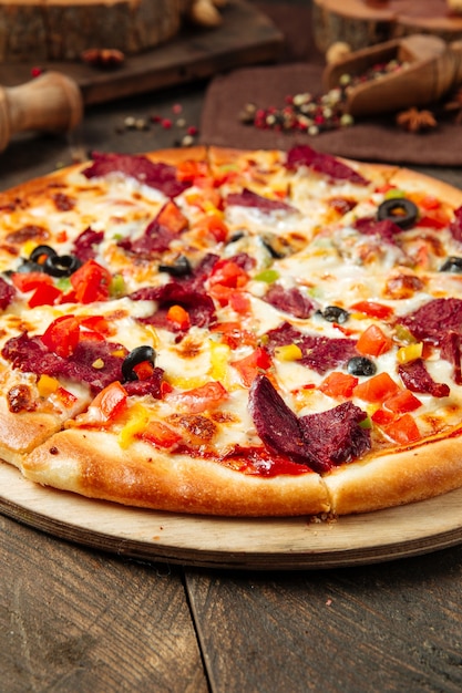 Closeup on pizza with smoked beef and vegetables on the wooden table