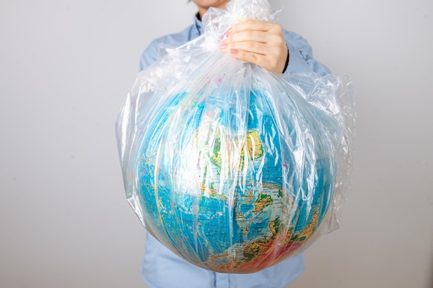 Foto un primo piano del pianeta terra sotto forma di un globo in un sacchetto di plastica il concetto di salvare il piano