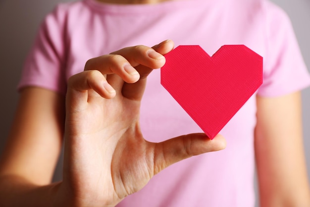 Closeup of plastic puzzle heart in female hand