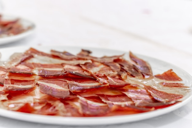 Closeup of a plate of iberian ham on a white plate Typical spanish food Selective focus