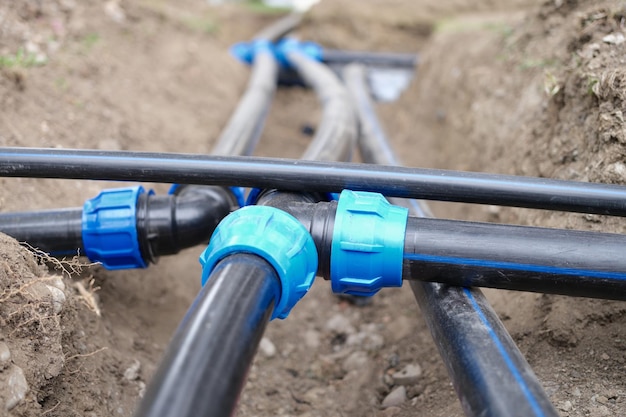 Closeup of plumbing water drainage or underground irrigation system elbow fittings and pvc