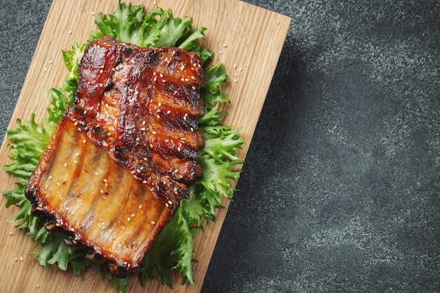 Closeup of pork ribs grilled with BBQ sauce.