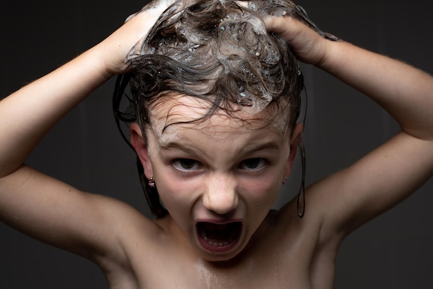 Photo closeup portrait of an angry little girl in the shower