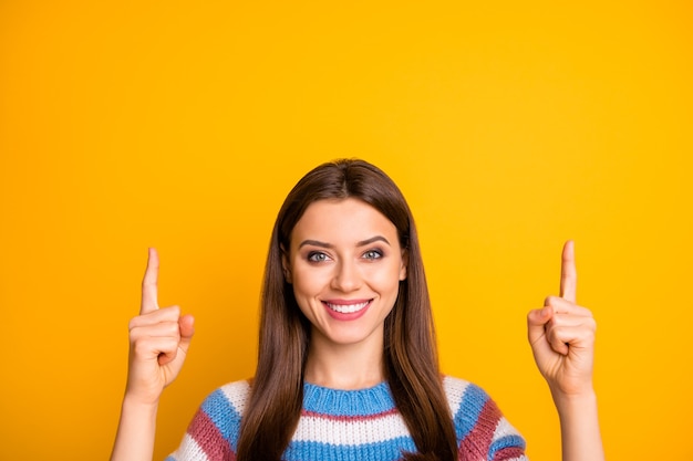 Closeup portrait of attractive glad girl pointing two forefingers up