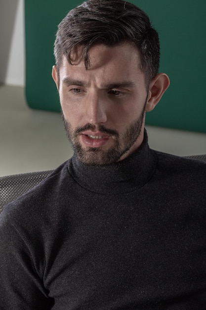 Closeup portrait of a bearded man on the green background